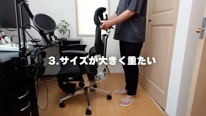 書斎でCOFO Chair Premiumを動かし、その大きさと重さを確かめている男性。
