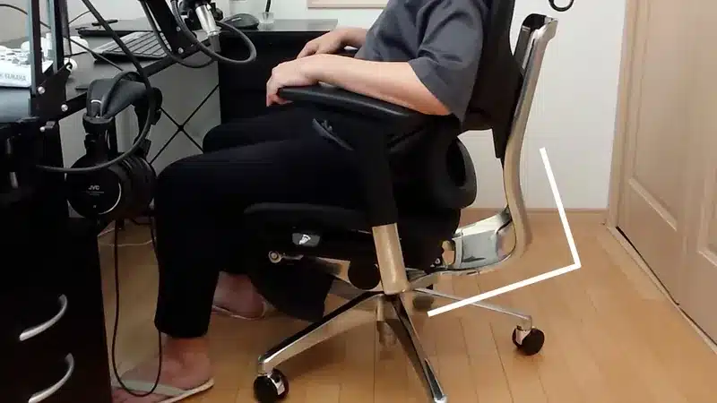 デスクに向かい、COFO Chair Premiumに深く腰掛ける様子。背もたれが体をしっかり支えている。